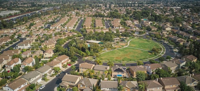 Drone shot of a spacious suburban neighborhood featuring a central park with numerous houses.
