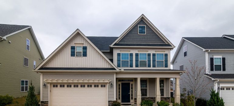 A modern two-story family home with a garage and landscaped yard in a suburban setting.