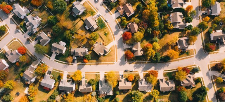 A vibrant aerial view of a suburban neighborhood with fall foliage and well-aligned houses.