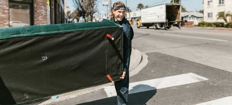 a mover carrying a couch, illustrating shipping and receiving service