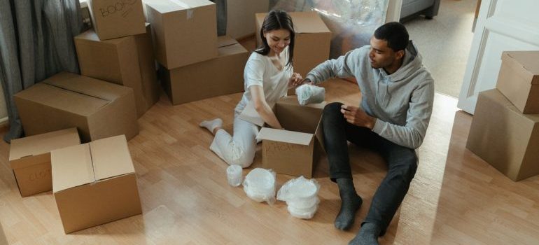 Young couple unpacking boxes in their new apartment, settling into their home.