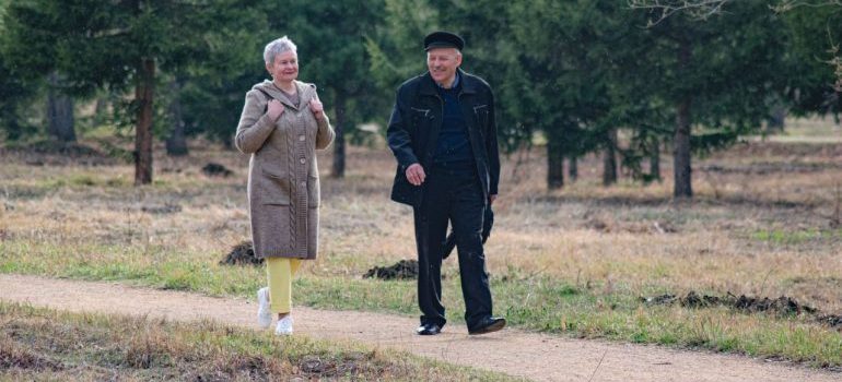 Happy senior couple strolling along a park path on a pleasant spring day.