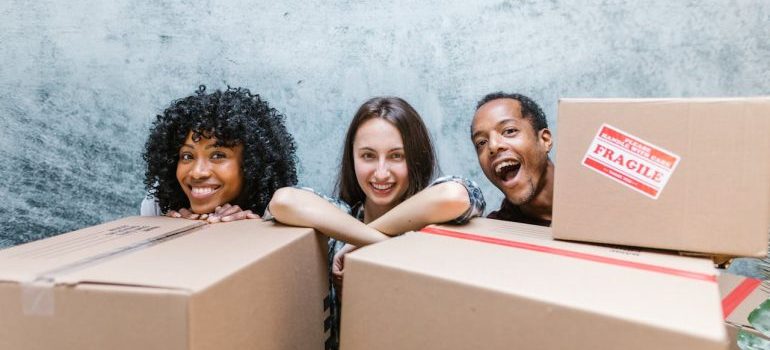 man and two women standing behind boxes