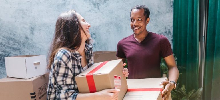 man and woman holding boxes